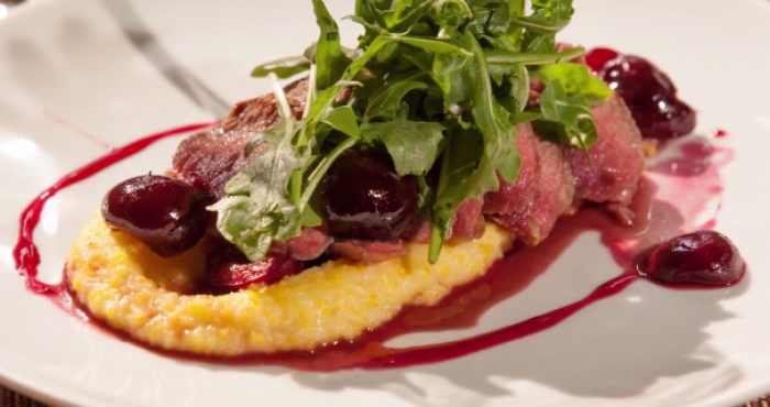 Seared Lamb with Cherry Agrodolce, Creamy Polenta, and Arugula